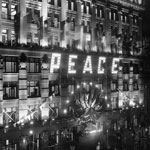 Celebrations, July 1919, to mark the end of World War I. The façade of the Commonwealth Bank of Australia’s head office, Sydney, was illuminated with the word ‘Peace’ in large letters. The flags of all the Allied nations were hung above the entrance. PN-000915