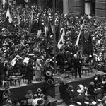 Sir James Joynton Smith, former Lord Mayor of Sydney, addresses the crowd on the opening day of the Second Peace Loan campaign, 6 August 1920. A banner in the background reads:‘WE Cried for men: THEY answered WE Cheered: THEY Sailed away WE Slept in peace: THEY Suffered It’s OUR turn: WE MUST PAY!’ PN-001805
