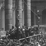 Official opening of the Diggers’ Loan in Martin Place, Sydney, 8 August 1921. The campaign was launched by the Governor of New South Wales, Sir Walter Davidson, from a platform erected outside the Commonwealth Bank head office. The celebrated Australian soprano Dame Nellie Melba was presented with a pair of silver scissors made in a repatriation workshop to cut the launching ribbon. PN-001842